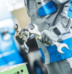 Technician Fixing Machinery Technician with Two Large Wrenches is Going To Fix Lathe Machine. Metalworking Theme.