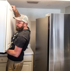workman-with-hat-and-beard-is-lifting-heaving-cabi-2025-02-15-18-04-05-utc workman-with-hat-and-beard-is-lifting-heaving-cabi-2025-02-15-18-04-05-utc